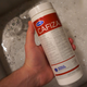 Bottle of Cafiza held over a sink full of hot water